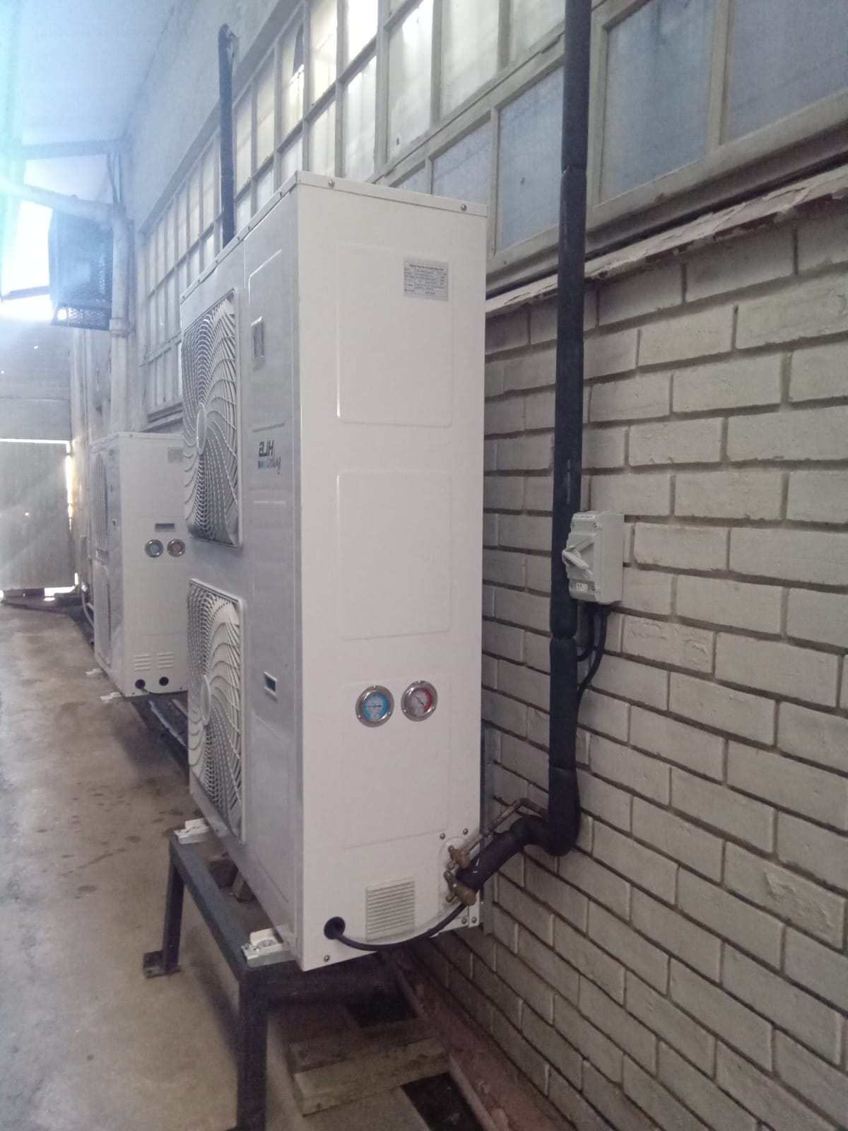 Commercial HVAC condensing units installed on wall-mounted brackets