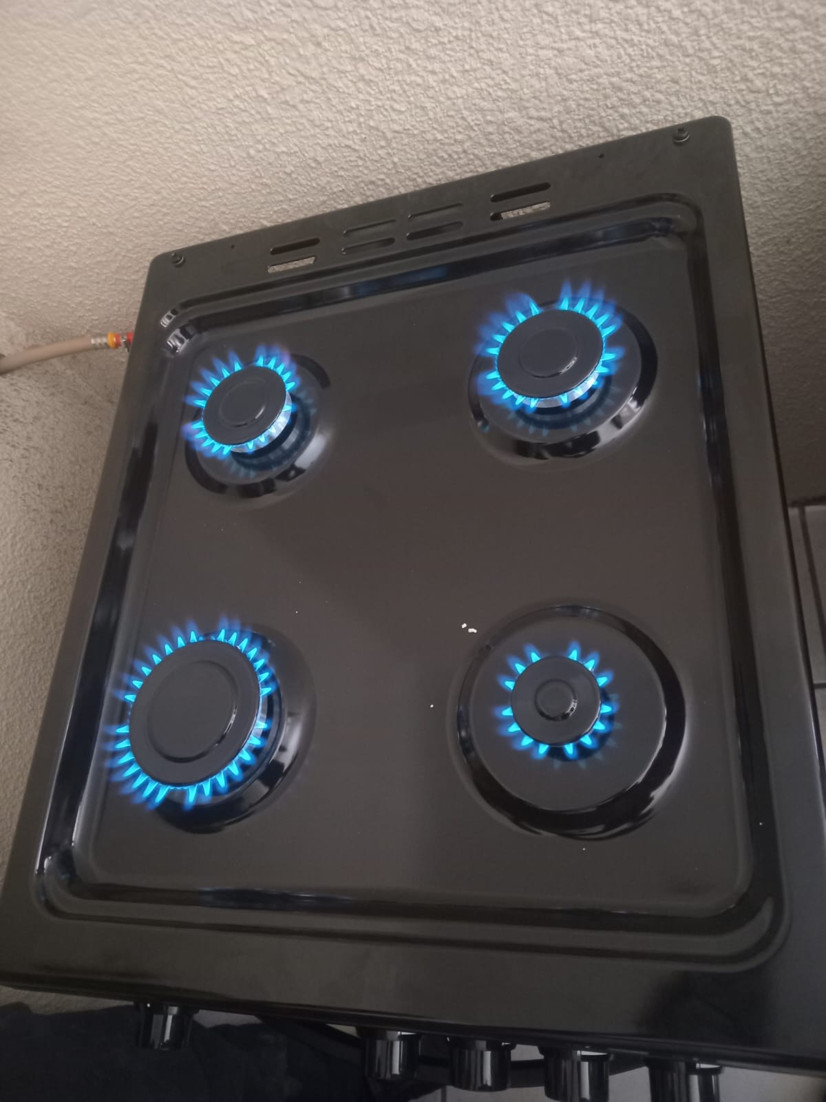 Gas stove hob installation with four burners lit