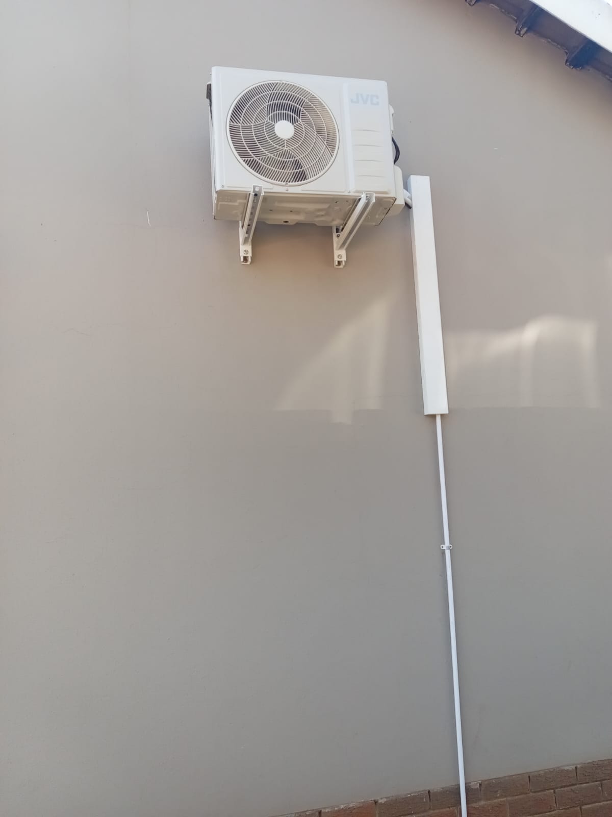 JVC air conditioning outdoor unit with neat pipe trunking on wall