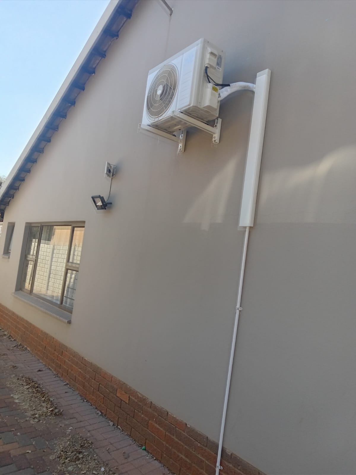 Air conditioning outdoor unit with trunking on house exterior