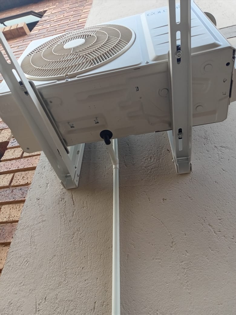 Goldair AC outdoor unit on wall brackets close-up underside view