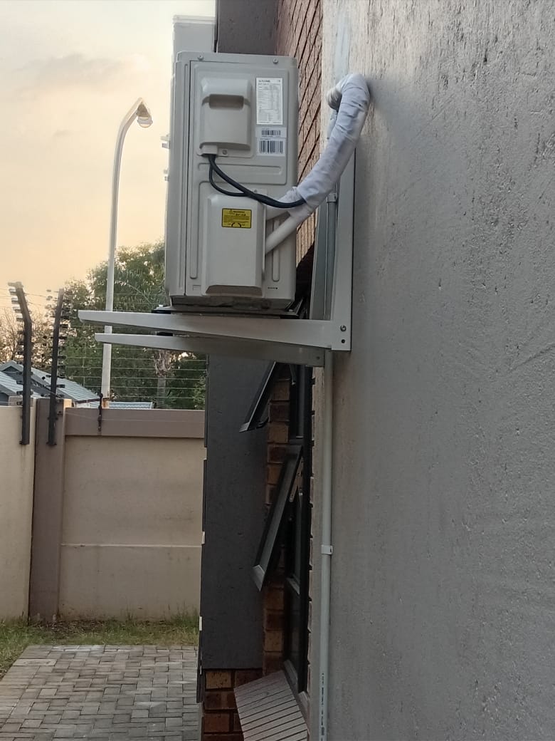 Air conditioning outdoor unit rear view with pipe lagging on wall bracket