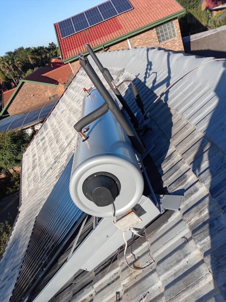 Solar geyser tank with insulated pipes on corrugated roof ridge