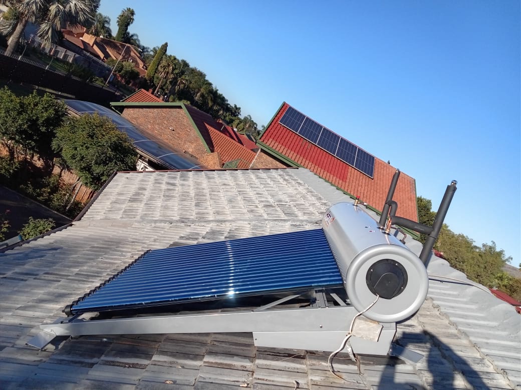 Solar geyser with flat plate collector and tank on concrete tile roof