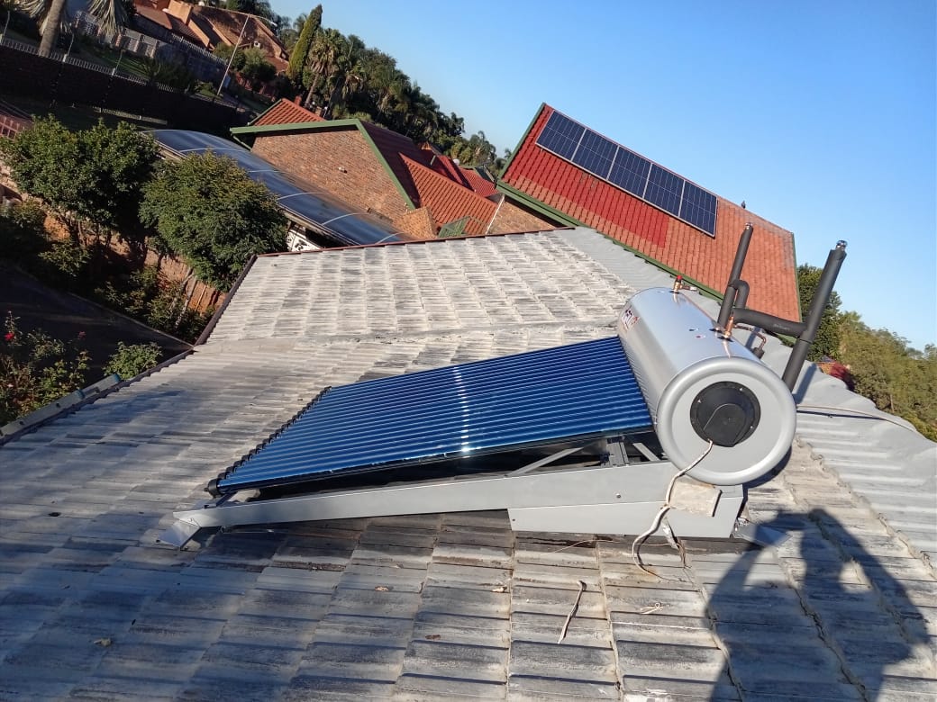 Solar geyser with flat plate collector on concrete tile roof wide view